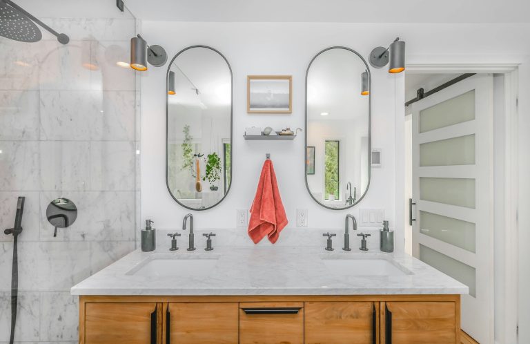 Bathroom remodel with double vanity, tile finishes, mirrors, lighting, and updated fixtures